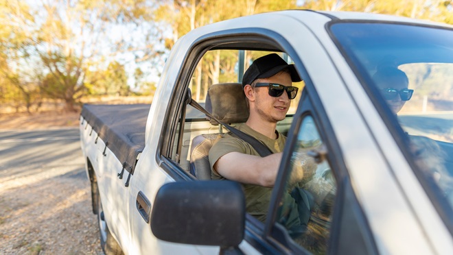 young man driving a white ute in Australia
